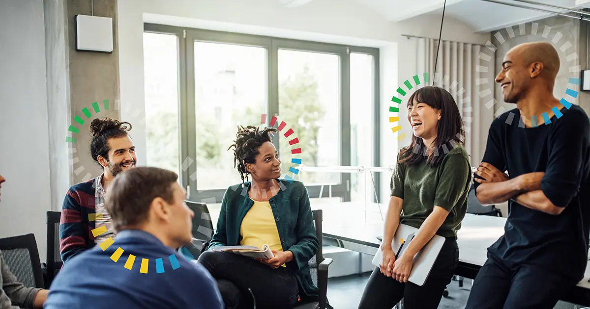 Group of diverse people laughing in a meeting.